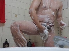 Young man strokes his cock in the shower to a satisfying climax